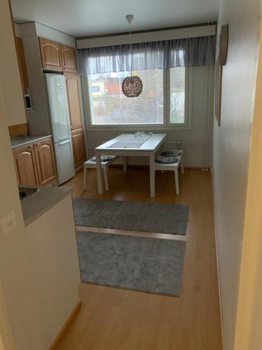 een keuken met een tafel en een eetkamer met een raam bij Keskustan kaksio in Rovaniemi