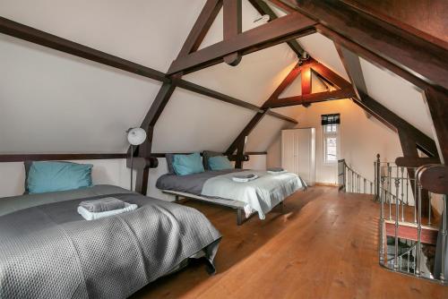 een slaapkamer met 2 bedden op een zolder bij Edam Suites in Edam