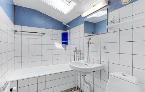 a white bathroom with a sink and a toilet at Stunning Apartment In Hasle With 4 Bedrooms in Hasle