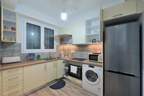 een keuken met een koelkast, een wasmachine en een droger bij Bella Ciao Guest House in Athene
