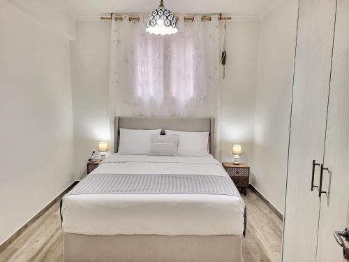 Un dormitorio con una gran cama blanca y una ventana en Bella Ciao Guest House, en Atenas