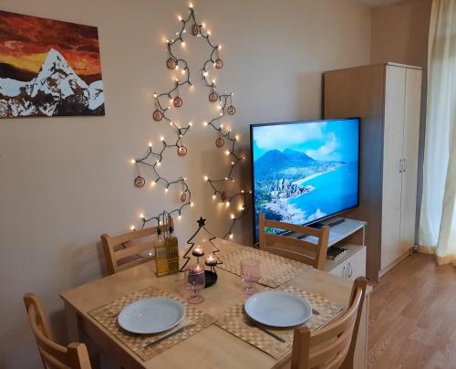 een eetkamer met een tafel en een kerstboom bij Apartment in Aspen Golf in Bansko