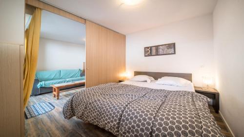 1 dormitorio con 1 cama y 1 sofá azul en T de Labrau-2109-Appart ski au pied- 6 pers en Allos