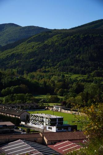 a view of a town with a green hill in the background at Hotel del Trueno in Ezcaray