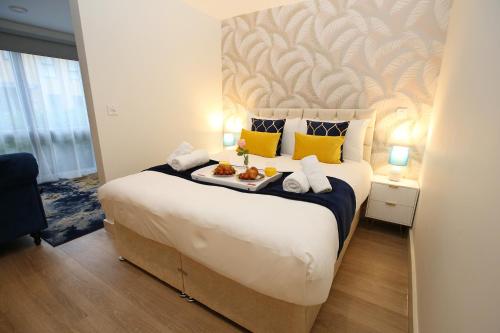 a bedroom with a large bed with a tray of food on it at Boutique Beautiful 1 Bed Abode Pass The Keys in Cambridge