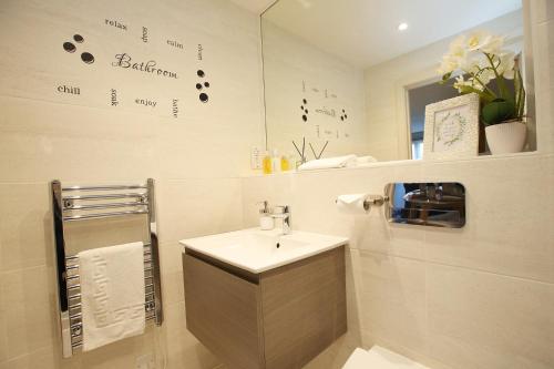a bathroom with a sink and a mirror at Boutique Beautiful 1 Bed Abode Pass The Keys in Cambridge