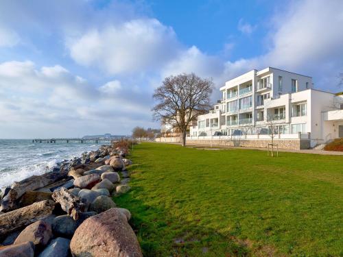 a large building next to the ocean with rocks at Ostseeresidenz Sassnitz F548 WG 16 mit Kamin, Sauna, Meerblick in Sassnitz