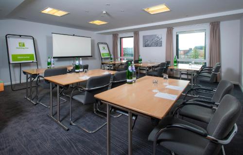 a conference room with tables and chairs and a whiteboard at Holiday Inn London West by IHG in London