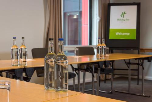 a conference room with four bottles of wine on a table at Holiday Inn London West by IHG in London