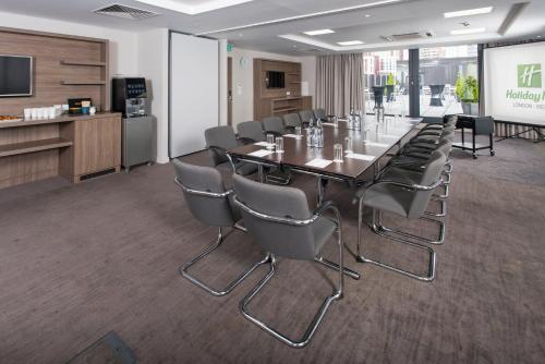 a conference room with a long table and chairs at Holiday Inn London West by IHG in London