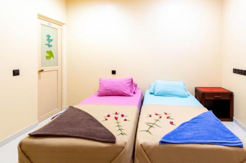 two beds sitting next to each other in a room at Night Star Dhangethi in Dhangethi