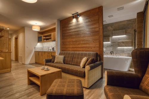 a living room with a couch and a bath tub at Apartmán Jelení Grúň Jasná in Belá