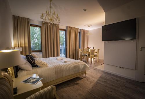 a hotel room with a bed and a dining room at APARTHOTEL Wałcz in Wałcz