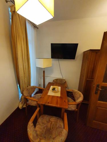a hotel room with a table and chairs and a television at Hotel Polak in Zamość