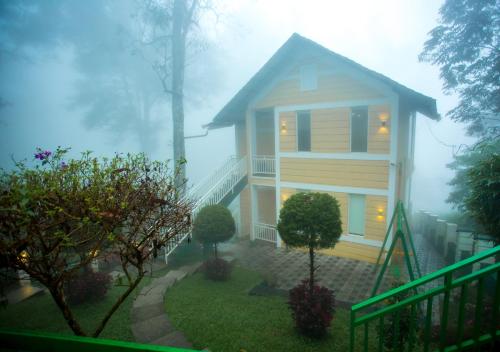 a house in the fog with a house at Areva Inn Munnar by VOYE HOMES in Munnar