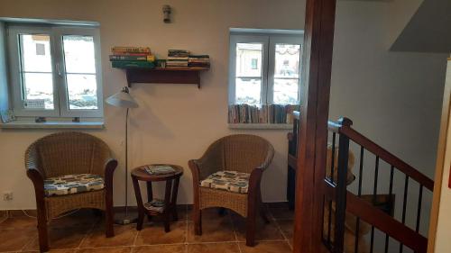 two chairs and a table in a room with windows at Aparthotel Teddy Kvilda in Kvilda