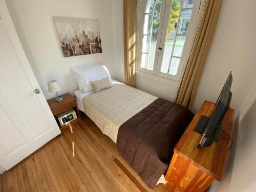 niewielka sypialnia z łóżkiem i telewizorem w obiekcie Hotel De Blasis w mieście Santiago