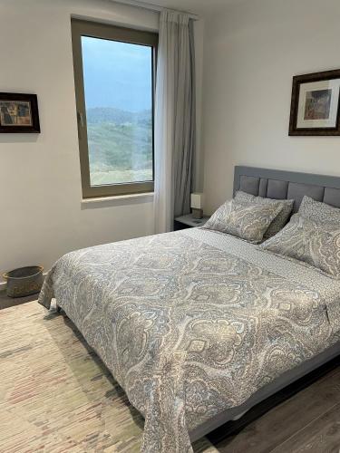 a bedroom with a large bed with a window at Duplex Seaview Condo in Durrës