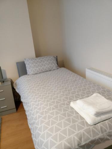 Dormitorio pequeño con cama con edredón blanco en Sandringham House, en Liverpool