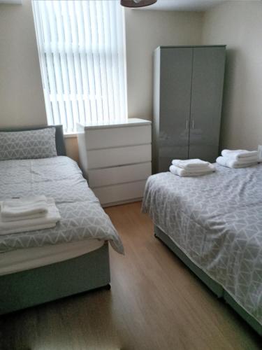 1 dormitorio con 2 camas, vestidor y armario en Sandringham House, en Liverpool