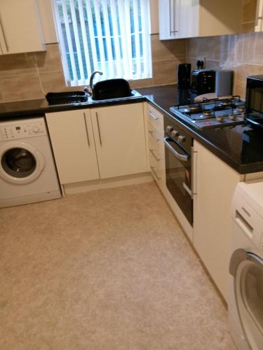 a kitchen with a sink and a dishwasher at Sandringham House in Liverpool