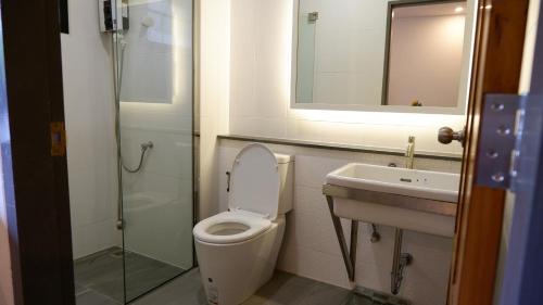 a bathroom with a toilet and a sink and a mirror at Nara Residence Trang in Trang