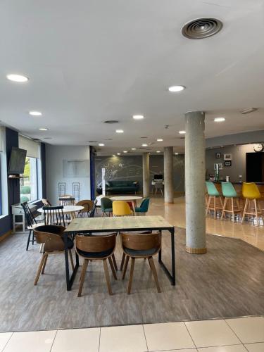 a lobby with a table and chairs in a room at Holiday Inn Express San Sebastian de los Reyes by IHG in San Sebastián de los Reyes