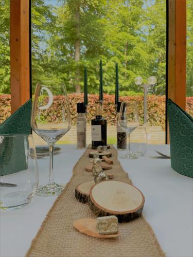 a table with glasses and wine bottles on it at Forsthaus Langenberg in Bansin