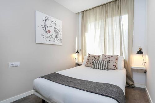 a white bedroom with a bed and a window at 3 Bdr&terrace Close To Subway in Hospitalet de Llobregat