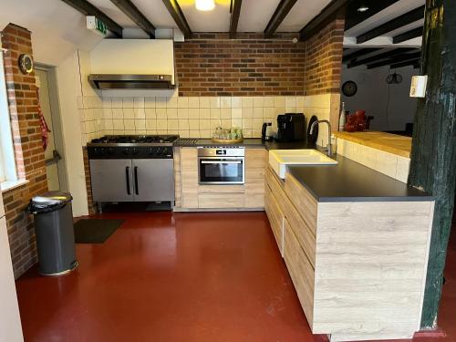 een keuken met een wastafel en een fornuis top oven bij Familiehuis voor 13 personen in Diever