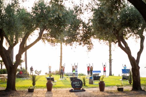a group of people doing yoga in a park at La Meridiana in Capo Vaticano