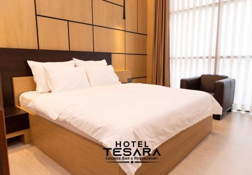 a hotel room with a bed and a chair at Hotel Tesara in Prizren