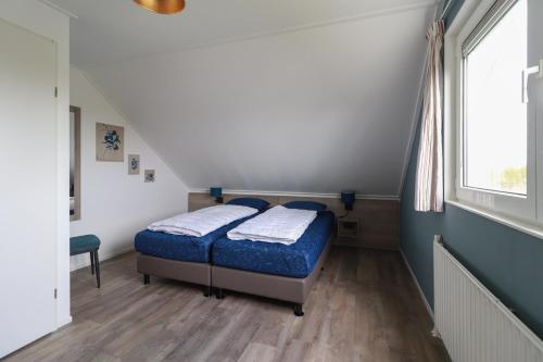 a bedroom with two beds and a window at Beach Resort Makkum in Makkum