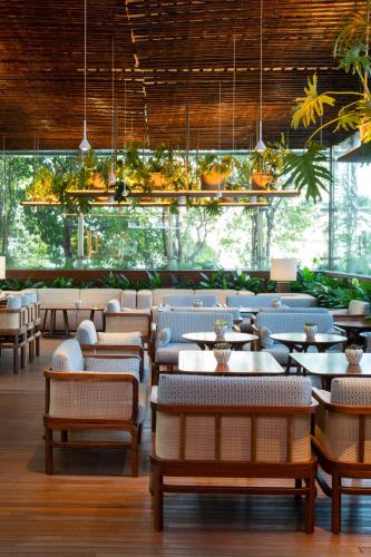 a restaurant with tables and chairs and plants at SANA Malhoa Hotel in Lisbon