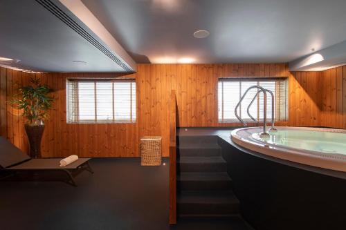 a bathroom with a jacuzzi tub and a staircase at SANA Malhoa Hotel in Lisbon