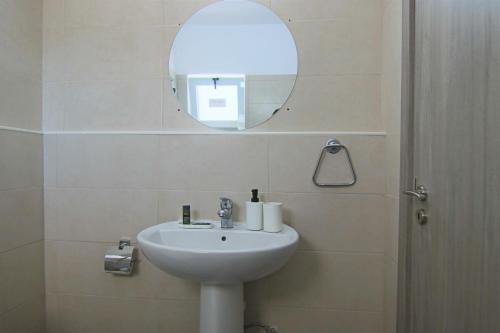 La salle de bains est pourvue d'un lavabo et d'un miroir. dans l'établissement Phaedrus Living: Seaside Luxury Flat Athina 117, à Paphos