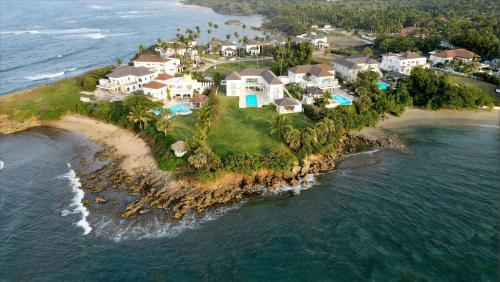 eine Luftansicht eines Hauses auf einer Insel im Ozean in der Unterkunft Peninsula Esmeralda Luxury Villas in San Felipe de Puerto Plata
