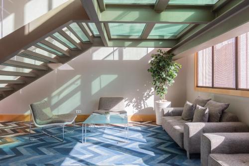 a living room with two chairs and a table at SANA Malhoa Hotel in Lisbon