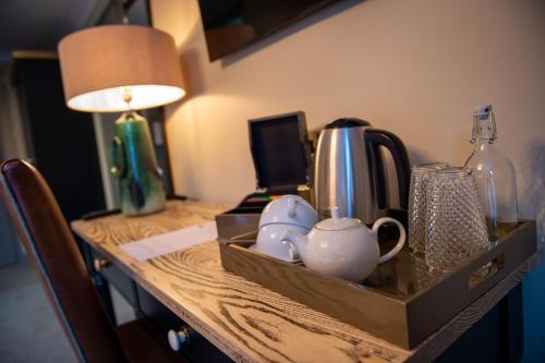 a table with a tray with tea cups and a lamp at The Red Lion Inn by Chef & Brewer Collection in Todwick