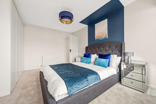 um quarto com uma cama grande e paredes azuis em Spacious 3 bed house in North Leeds perfect for families & longer stays em Adel