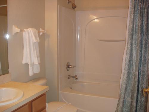 ein Badezimmer mit Dusche, Toilette und Waschbecken in der Unterkunft Four Bedroom Villa in Coral Cay in Kissimmee