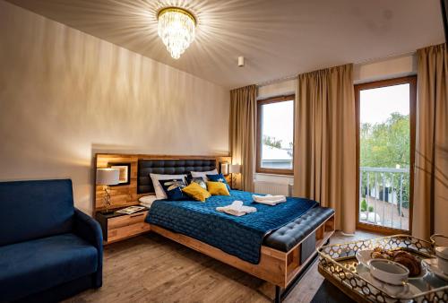 um quarto com uma cama, um sofá e uma janela em APARTHOTEL Wałcz em Wałcz