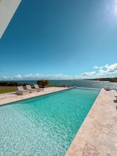 a swimming pool with a view of the water at Peninsula Esmeralda Luxury Villas in San Felipe de Puerto Plata