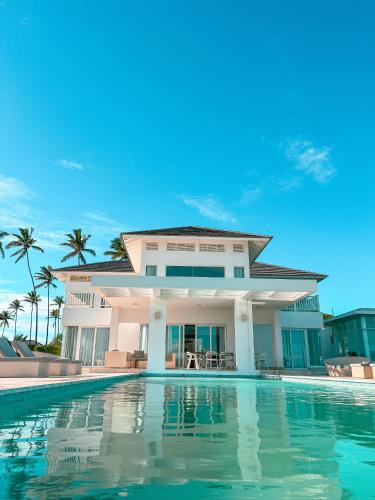 a villa with a swimming pool in front of a house at Peninsula Esmeralda Luxury Villas in San Felipe de Puerto Plata