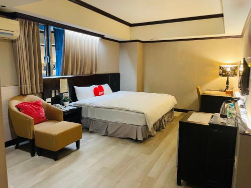 a hotel room with a bed and a chair at Felicity Business Hotel in Taichung