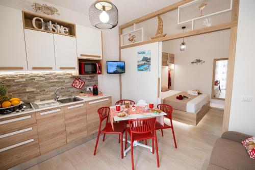 a kitchen and living room with a table and chairs at MARE e Terra Holiday fronte mare in San Vito lo Capo