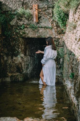a woman standing in a tunnel in the water at TheVagar Countryhouse in Belmonte