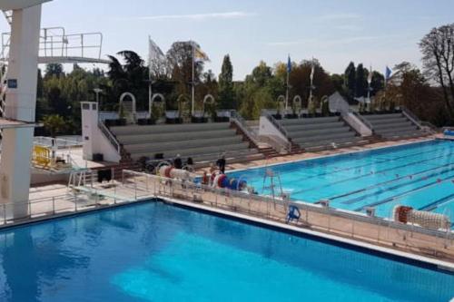 une grande piscine avec de l'eau bleue dans l'établissement Aux portes de Paris , un 3 pcs bien aménagé, à Nogent-sur-Marne