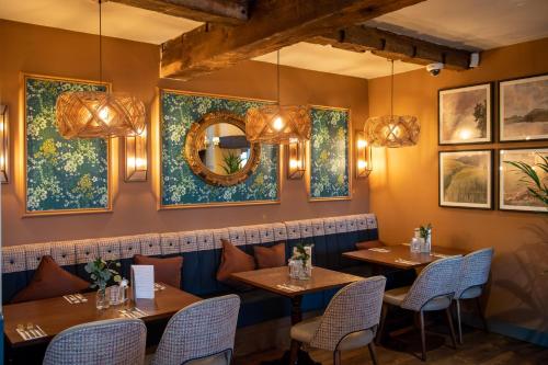 a restaurant with two tables and chairs and a mirror at The Red Lion Inn by Chef & Brewer Collection in Todwick