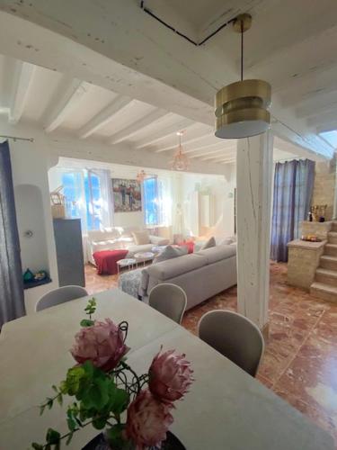 un salon avec une table avec des fleurs dessus dans l'établissement Villa authentique à Saint-Maximin-la-Sainte-Baume avec piscine privée, à Saint-Maximin-la-Sainte-Baume